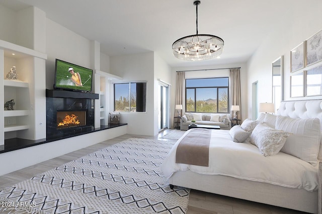30600 N Pima Rd Unit 49, Scottsdale, AZ 85266 - bedroom featuring a chandelier, a warm lit fireplace, access to exterior, and wood finished floors