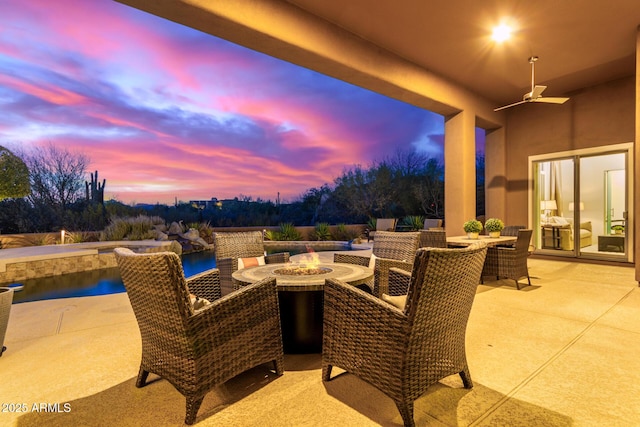 30600 N Pima Rd Unit 49, Scottsdale, AZ 85266 - patio terrace at dusk with outdoor dining area, a ceiling fan, and an outdoor fire pit