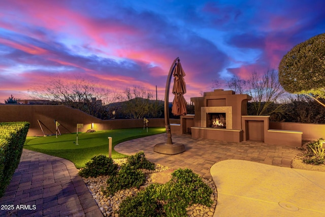 30600 N Pima Rd Unit 49, Scottsdale, AZ 85266 - view of front facade featuring stucco siding, a lit fireplace, and a patio area