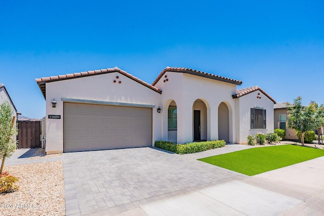 mediterranean / spanish home with a front yard and a garage