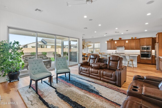 living room with ceiling fan and light wood-type flooring