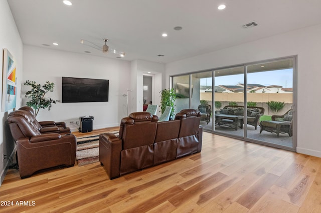 living room with ceiling fan and light hardwood / wood-style flooring