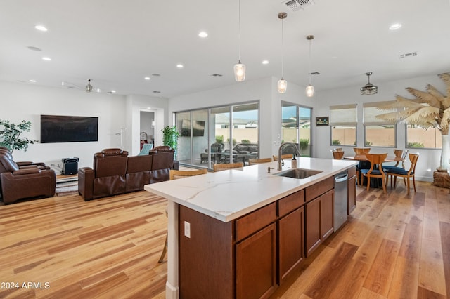 kitchen featuring sink, stainless steel dishwasher, ceiling fan, an island with sink, and decorative light fixtures