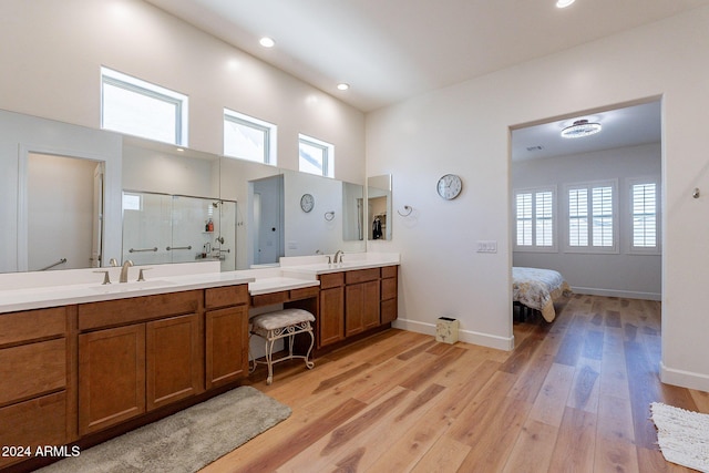 bathroom featuring hardwood / wood-style floors, vanity, an enclosed shower, and a high ceiling