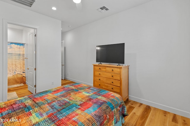 bedroom with connected bathroom, light hardwood / wood-style flooring, and ceiling fan