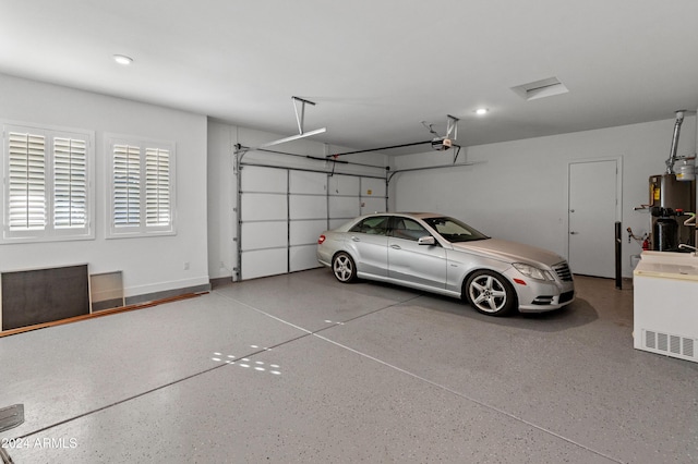 garage with gas water heater and a garage door opener