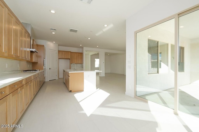 kitchen with visible vents, recessed lighting, a sink, light countertops, and tasteful backsplash