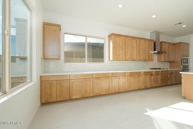 kitchen featuring backsplash, wall chimney range hood, light countertops, stovetop, and recessed lighting