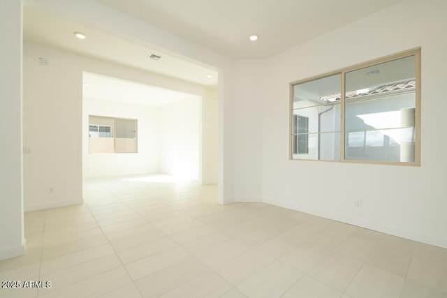 empty room featuring light tile patterned floors, visible vents, recessed lighting, and baseboards