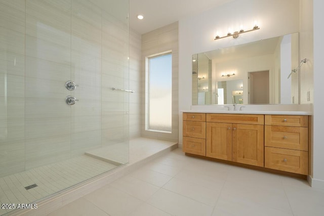 bathroom featuring vanity, tile patterned floors, and a tile shower