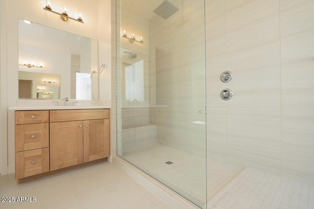 full bathroom featuring tile patterned floors, vanity, and a tile shower