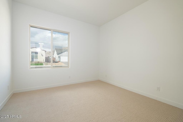 spare room with baseboards and carpet floors