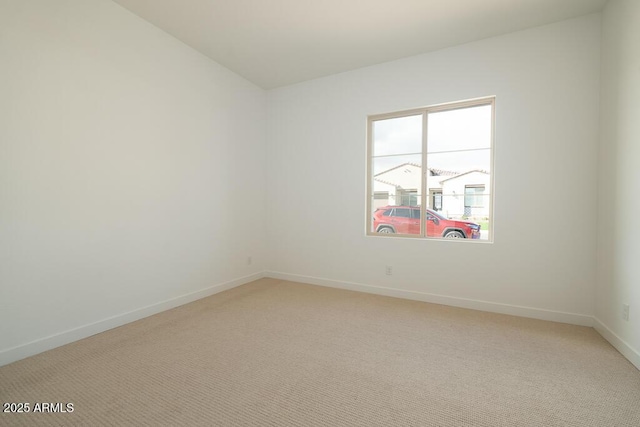 unfurnished room featuring light colored carpet and baseboards