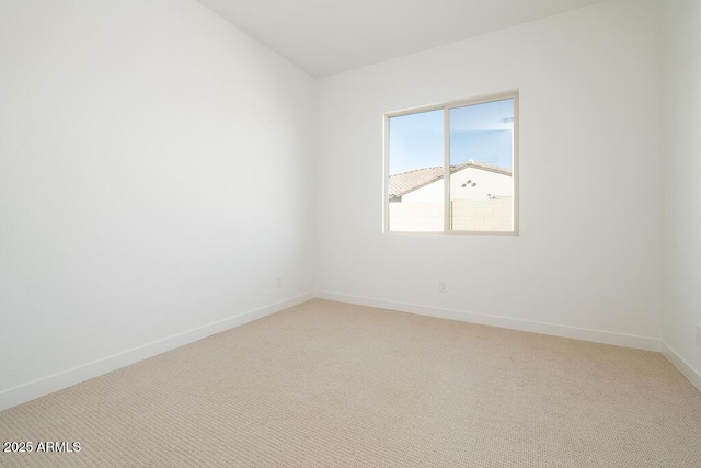 unfurnished room featuring baseboards and light colored carpet