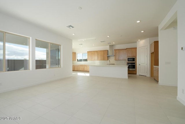 unfurnished living room with visible vents, recessed lighting, baseboards, and a sink