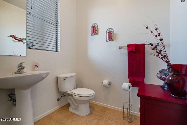 bathroom with toilet and tile patterned floors