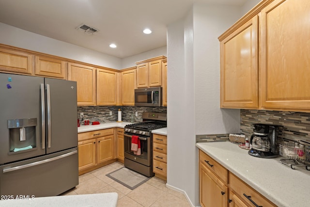 kitchen featuring appliances with stainless steel finishes, tasteful backsplash, and light tile patterned flooring