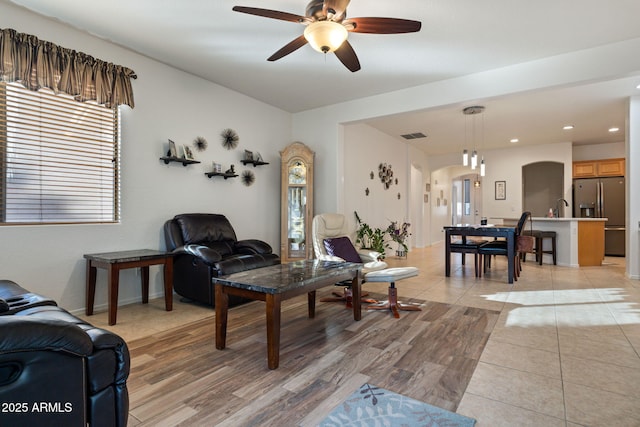 living room with sink, ceiling fan, and light hardwood / wood-style floors