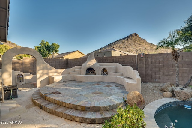 view of patio featuring a pool and exterior fireplace