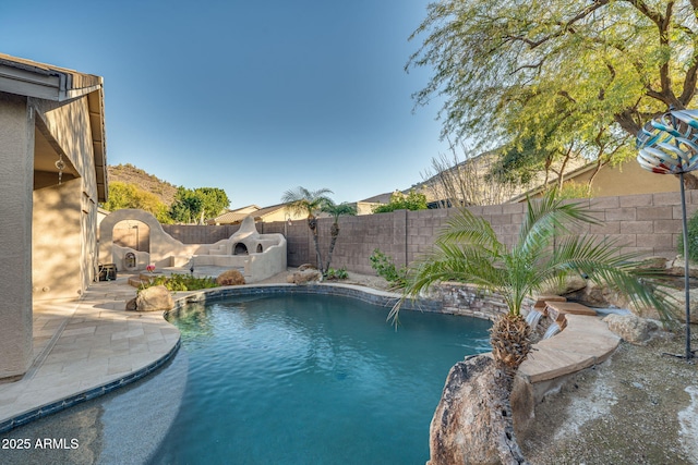 view of pool with a patio, pool water feature, and a fireplace