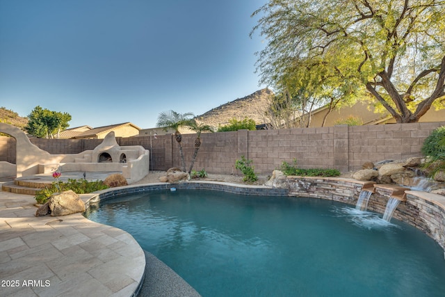 view of pool featuring a patio area, an outdoor stone fireplace, and pool water feature