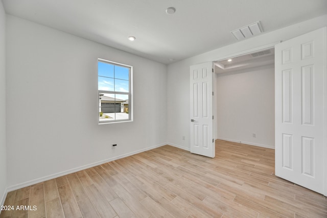 unfurnished bedroom featuring light wood-type flooring and a closet