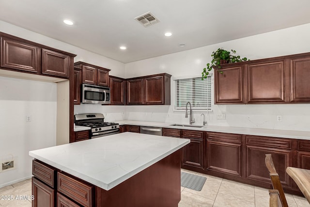 kitchen featuring a center island, light countertops, visible vents, appliances with stainless steel finishes, and a sink