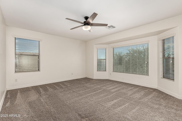 empty room with ceiling fan, carpet, visible vents, and baseboards