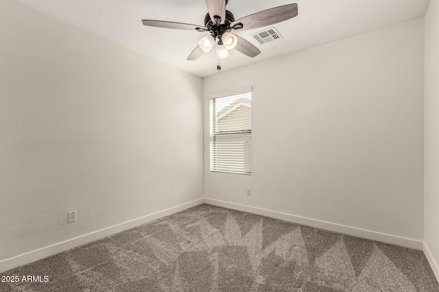 carpeted spare room featuring a ceiling fan, visible vents, and baseboards