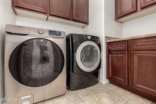 laundry room featuring light tile patterned flooring, washing machine and dryer, and cabinet space