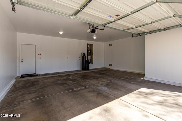 garage featuring a garage door opener, water heater, and baseboards