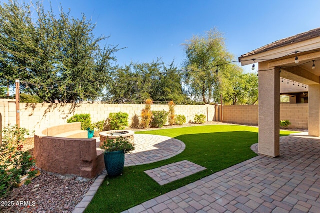 view of yard with a fire pit, a patio, and a fenced backyard