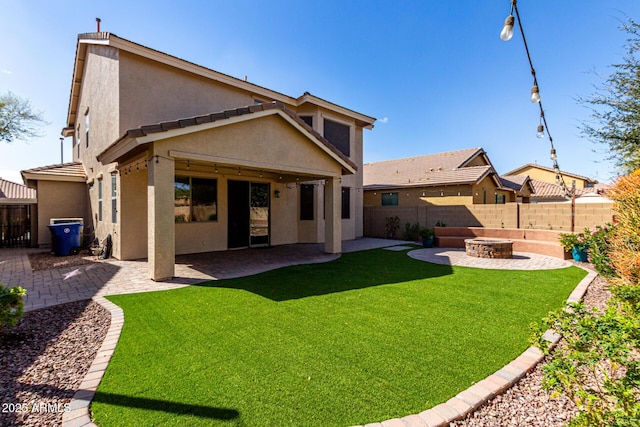 rear view of house featuring a fenced backyard, a lawn, a patio, and stucco siding