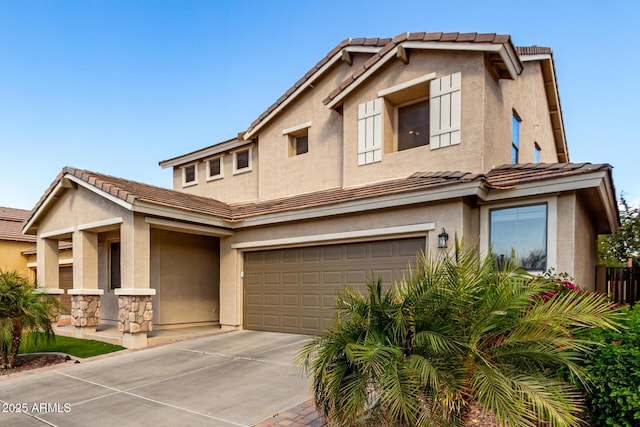 view of front of property with a garage, concrete driveway, a tiled roof, and stucco siding