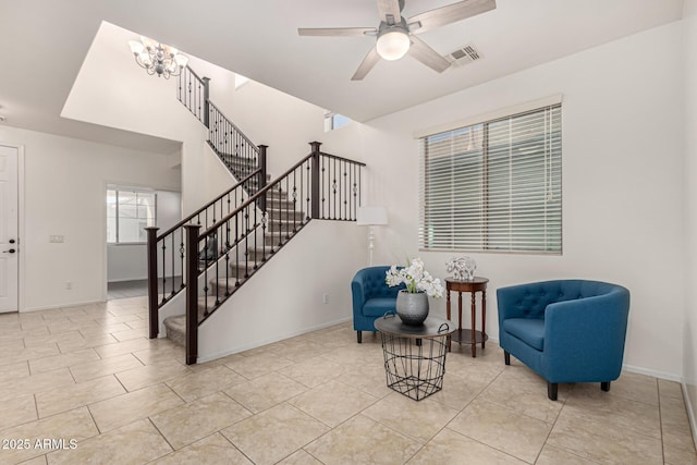 sitting room featuring baseboards, visible vents, tile patterned floors, stairs, and ceiling fan with notable chandelier