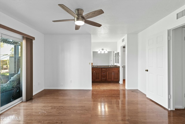 unfurnished living room with ceiling fan and light wood-type flooring