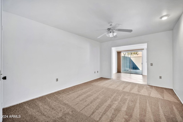 carpeted spare room with ceiling fan