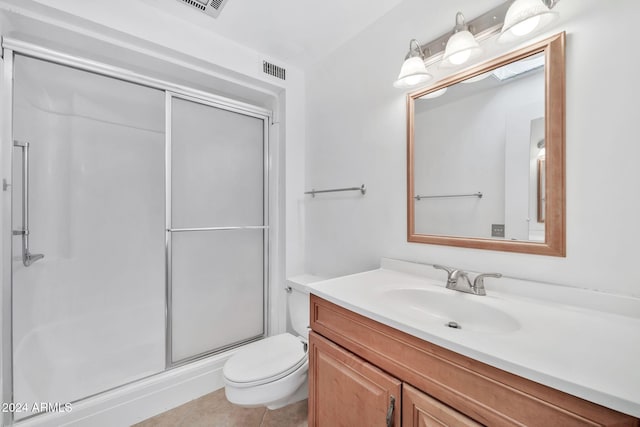 bathroom featuring vanity, toilet, a shower with shower door, and tile patterned flooring