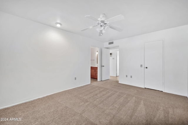 unfurnished bedroom with light carpet, a closet, ensuite bath, and ceiling fan