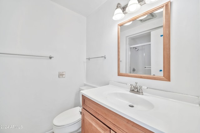 bathroom with toilet, walk in shower, and vanity