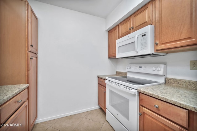 kitchen with light tile patterned flooring and white appliances