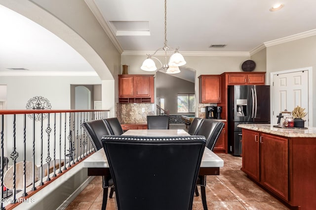 dining area featuring vaulted ceiling, tile patterned floors, a notable chandelier, and ornamental molding