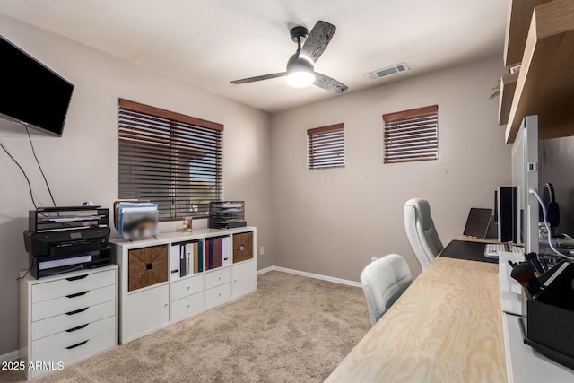 carpeted office space featuring ceiling fan