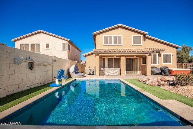 back of house featuring a fenced in pool and a patio