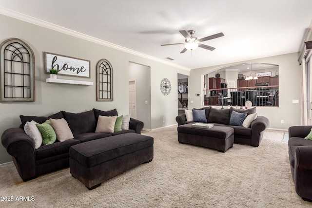 carpeted living room featuring ceiling fan and ornamental molding