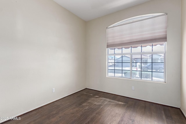 unfurnished room with dark wood-type flooring