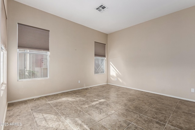 tiled spare room with visible vents and baseboards