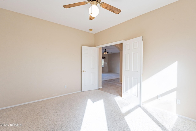 carpeted spare room featuring ceiling fan