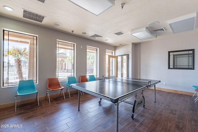 playroom featuring dark wood-type flooring and a textured ceiling