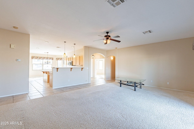 unfurnished living room featuring light colored carpet and ceiling fan